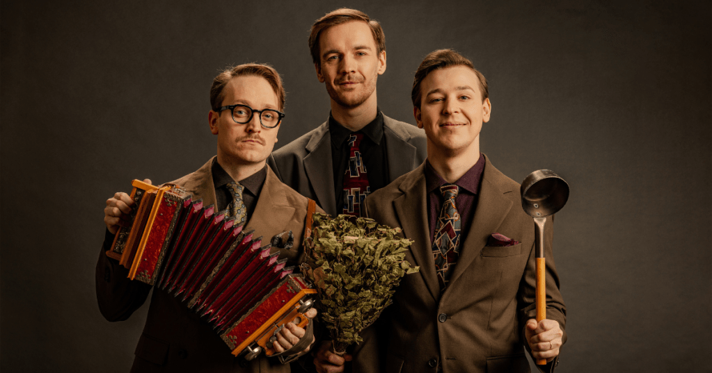 Three men in vintage suits holding a vihta, a sauna ladle, and an accordion – members of the Finnish band KAJ